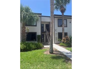 Two-story condo building with a charming entrance and well-maintained landscaping, including palm trees at 376 Moorings Cove Dr # 6C, Tarpon Springs, FL 34689