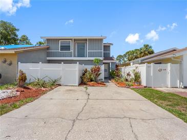 Well-maintained two-story home featuring a fenced yard, colorful landscaping, and a spacious driveway at 4813 Glenaire Ct, Tampa, FL 33624