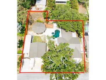 An aerial view showcasing a private backyard with a pool, spa, and expansive lot outlined in red at 11988 117Th St, Seminole, FL 33778
