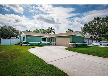 Charming single-story home features a well-manicured lawn, spacious driveway and an attached two-car garage at 12873 Cumberland Dr, Largo, FL 33773