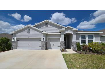 Charming single-story home with a three-car garage and stone accents at 13111 Pepper Stem St, Spring Hill, FL 34609