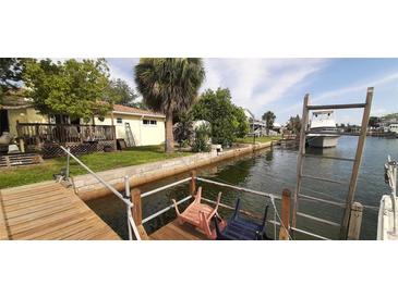 Waterfront canal view featuring lush landscaping, a private dock, and boat-friendly access for serene coastal living at 13815 San Juan Ave, Hudson, FL 34667