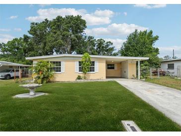 Charming single-story home featuring a well-manicured lawn and a welcoming carport at 2044 Temple Ter, Clearwater, FL 33764