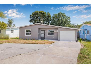 Charming gray single-story home with a well-manicured lawn and a driveway leading to an attached garage at 5326 22Nd N Ave, St Petersburg, FL 33710