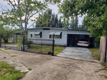Single-story home with attached carport and chain-link fence around the perimeter at 6095 108Th N Ave, Pinellas Park, FL 33782