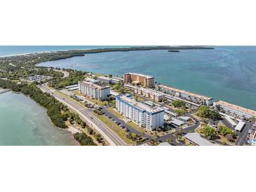 A complex of apartment buildings with one painted white with a blue roof, located in a coastal setting at 7 Elgin Pl # 202, Dunedin, FL 34698