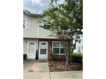 Charming two-story townhome with brick accents and a well-manicured front yard at 7616 Colonial Ct, Tampa, FL 33615