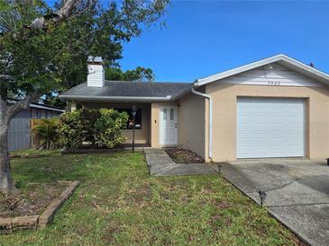 Cozy single-story home featuring a one car garage, well maintained lawn, and charming front landscape at 7920 52Nd N St, Pinellas Park, FL 33781