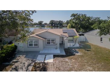 Charming single-story home with fresh exterior paint, solar panels, and a view of the serene lake at 12416 Queensland Ln, Tampa, FL 33625