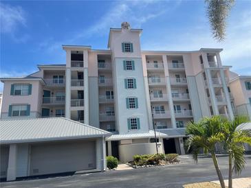 Beautiful condo with multiple floors, light pink exterior, and blue window shutters at 13313 Gasparilla Rd # 401, Placida, FL 33946