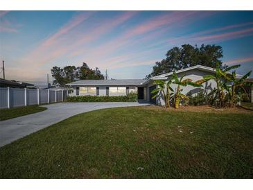 Charming single-story home with a well-maintained lawn, lush greenery, and a long driveway leading to the entrance at 1701 62Nd S Ter, St Petersburg, FL 33712