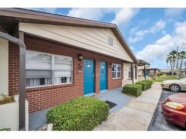 Charming exterior showing colorful doors, brickwork, and well-maintained landscaping, with parking at 24862 Us Highway 19 N # 1105, Clearwater, FL 33763