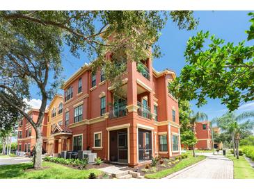 Attractive three-story building featuring stucco walls, balcony, and manicured landscaping at 2741 Via Cipriani # 934B, Clearwater, FL 33764