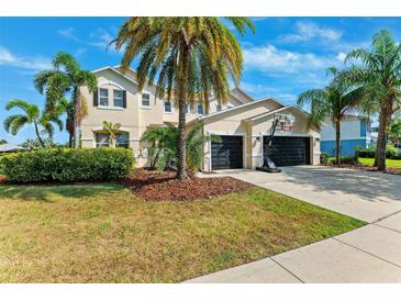 Charming two-story home features lush landscaping, a basketball hoop, and a spacious three-car garage at 5457 Sandy Shell Dr, Apollo Beach, FL 33572