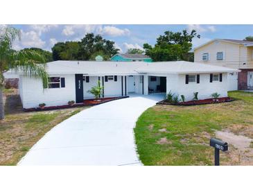 Charming single-story home featuring a white brick facade and well-maintained landscaping at 6304 Memorial Hwy, Tampa, FL 33615