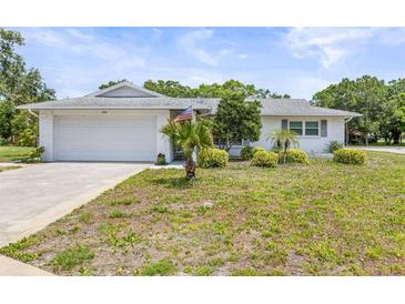 Charming single-story home with a well-manicured lawn and attached garage at 1410 Brighton Ct, Palm Harbor, FL 34684