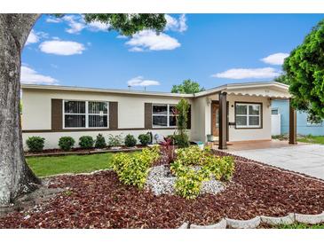 Charming single-story home featuring a well-maintained lawn and beautiful, mature landscaping at 1512 56Th N Ave, St Petersburg, FL 33703