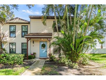 Charming two-story home with a light blue door and well-maintained landscaping at 1515 Bayshore Blvd # 38, Dunedin, FL 34698