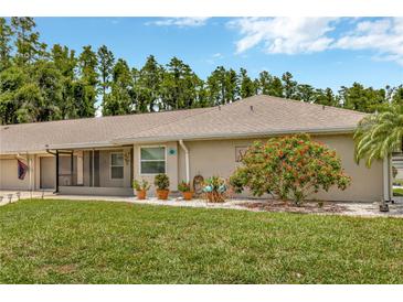 Charming single-story home with well-manicured lawn, mature landscaping, and screened in lanai at 1604 Comfy Ct, Sun City Center, FL 33573