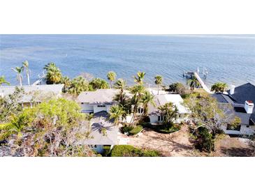 Waterfront property with lush landscaping, dock, and serene bay views, offering a tranquil retreat at 1967 Brightwaters Ne Blvd, St Petersburg, FL 33704