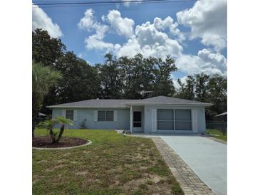 Charming single-story home with lush landscaping and a well-manicured lawn under a blue sky at 2226 Giralda Ave, Spring Hill, FL 34606