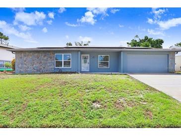 Charming single-story home featuring a stone accent wall and a well-manicured lawn in a residential neighborhood at 3917 Casaba Loop, Valrico, FL 33596