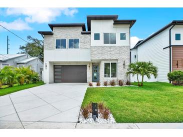 Striking modern two-story home with stone accents, sleek garage door, and freshly manicured lawn at 710 W Plymouth St, Tampa, FL 33603