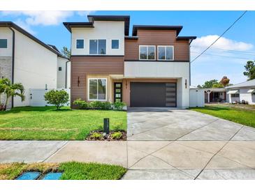 Modern two-story home featuring mixed-material facade, well-maintained lawn, and contemporary garage door for enhanced curb appeal at 712 W Plymouth St, Tampa, FL 33603