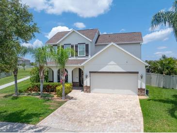 Charming two-story home featuring a brick driveway, lush landscaping, and a welcoming front porch at 11904 Greenchop Pl, Riverview, FL 33579
