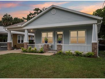 Charming single-story home featuring a inviting front porch and a well-manicured lawn at 311 W Ida St, Tampa, FL 33603