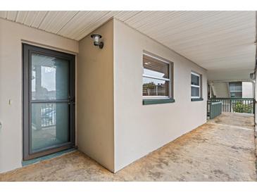 A ground-level exterior view of a condo entrance with windows and a covered walkway at 1028 Apollo Beach Blvd # 203, Apollo Beach, FL 33572