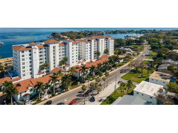 Upscale waterfront condominium building featuring a white facade, tile roof, and lush landscaping at 1325 Snell Isle Ne Blvd # 708, St Petersburg, FL 33704