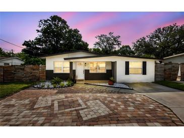 Charming home featuring neutral paint, decorative rock, shutters, and paver driveway at 2112 Ranchita Trl, Holiday, FL 34690