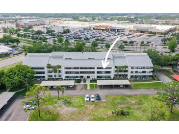 Condo building featuring well-maintained landscaping, covered parking, and proximity to shopping centers at 2581 Countryside Blvd # 2309, Clearwater, FL 33761