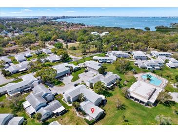 Stunning aerial view of a condo community with a pool, trees, and a view of a large body of water in the background at 3268 39Th S St # A, St Petersburg, FL 33711