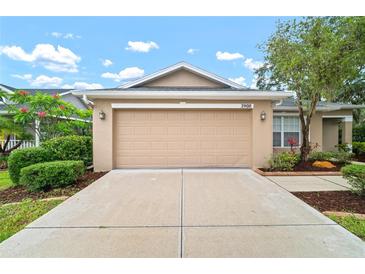 Charming home featuring an attached two-car garage, a well-manicured lawn, and beautiful landscaping at 3908 Douglas Hill Pl, Parrish, FL 34219