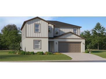 Two-story home featuring a two-car garage, siding, and a beautifully landscaped front yard at 5724 Red Kite Dr, Wimauma, FL 33598
