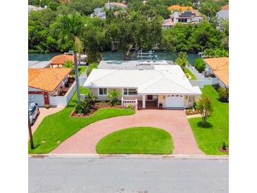 Charming home featuring a well manicured lawn, beautiful landscaping, and a brick circular driveway at 715 45Th Ne Ave, St Petersburg, FL 33703