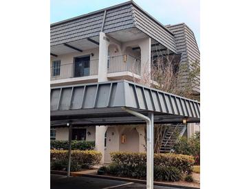 Multi-level condo building featuring a covered parking area and balcony at 8765 Bardmoor Blvd # 108, Seminole, FL 33777