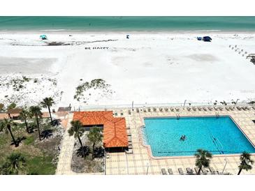 Stunning aerial view of pool and beachside property with sparkling ocean waters and the words, 