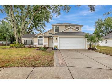 Charming two-story home with a well-manicured lawn, inviting walkway, and attached two-car garage at 1808 Sawhorse Ct, Lutz, FL 33559