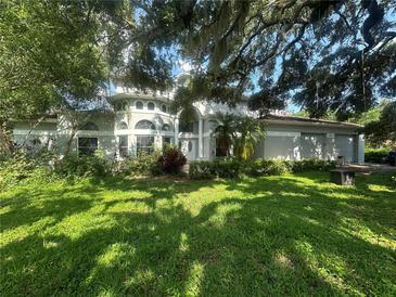 Charming two-story home with a well-manicured lawn, mature landscaping, and shade trees at 1931 Oak Ridge Ct, Clearwater, FL 33759