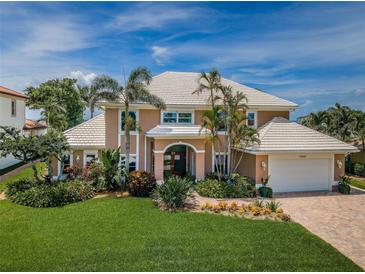 Beautiful two-story home with lush landscaping, tile roof, and a brick driveway at 1988 Carolina Ne Cir, St Petersburg, FL 33703