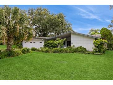 Well-maintained home exterior features a manicured lawn and mature landscaping at 2035 Nolan Dr, Dunedin, FL 34698