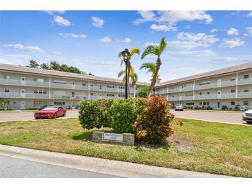 Well-maintained condo complex with mature landscaping, signage, and convenient parking on a sunny day at 2261 Swedish Dr # 47, Clearwater, FL 33763