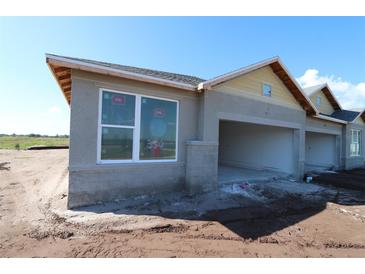 View of exterior shows the two-car garage, tan siding and large window at 2824 Marrakesh Ln, Sarasota, FL 34234