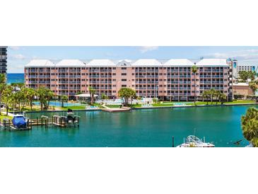 Waterfront condo building with private docks and amenities under a bright sunny sky at 5445 Gulf Blvd # 210, St Pete Beach, FL 33706