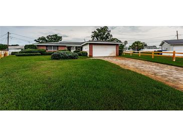 Charming home with lush green lawn, brick-lined driveway, and a well-manicured landscape at 5919 35Th N Ave, St Petersburg, FL 33703