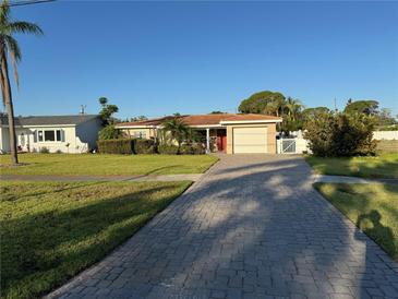 Charming single-Gathering home featuring a long brick driveway and well-maintained landscaping at 6034 Bayou Grande Ne Blvd, St Petersburg, FL 33703