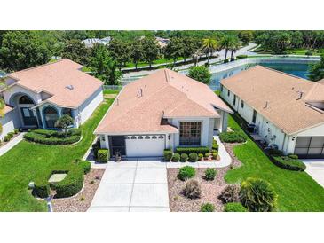 Charming single-story home featuring a two-car garage, manicured landscaping, and inviting curb appeal at 11121 Cherrywood Ct, Spring Hill, FL 34609